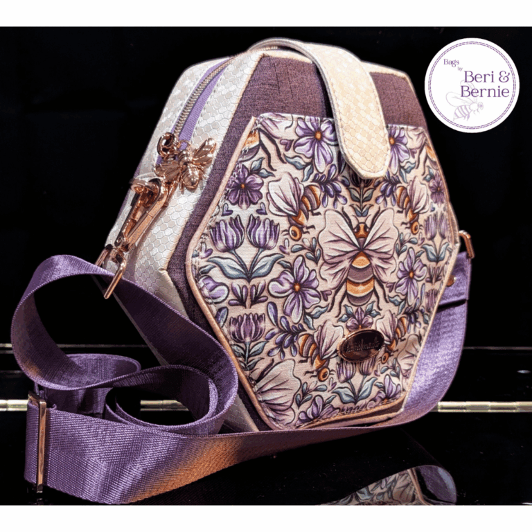 Side view of purple hexagon cross body bag with bee floral print front panel and decorative bee zipper pull – customer make of The Hexelle sewing pattern by Studio7t7